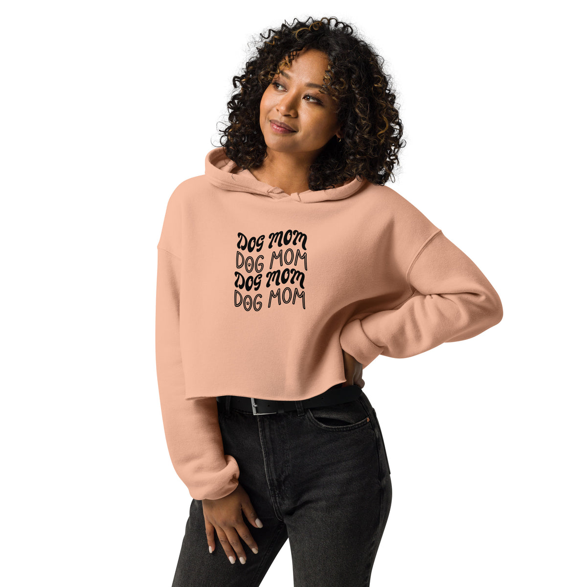 Woman wearing a salmon crop hoodie with repeating "dog mom" text, showcasing a cozy streetwear sweatshirt with a flattering cropped cut.